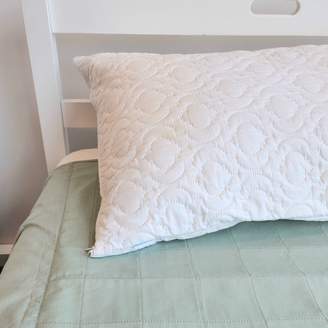Pillow Protector Waterproof Quilted on bed with green waterproof sheet