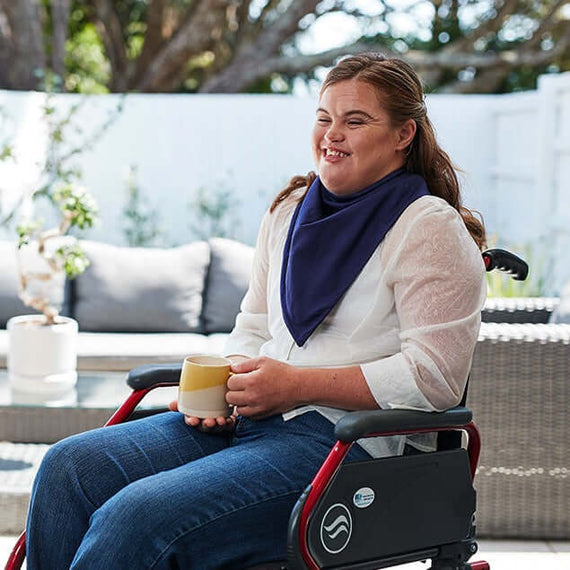 women on wheelchair wear bandana bib holding cup
